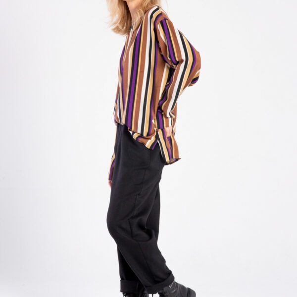 Modelka w bluzce Niigata Stripes od delCane, ujęcie z boku, twarz skierowana do przodu, widoczna cała sylwetka.