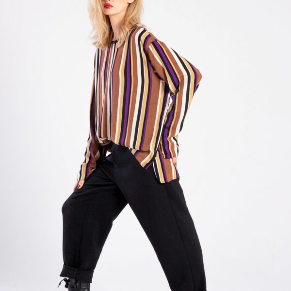 Modelka w bluzce Niigata Stripes od delCane, ujęcie z boku w ruchu, twarz skierowana do przodu, widoczna cała sylwetka.