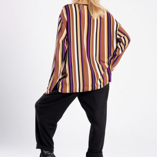 Modelka w bluzce Niigata Stripes od delCane, widok z tyłu, lekko widoczny profil twarzy, luźna poza.