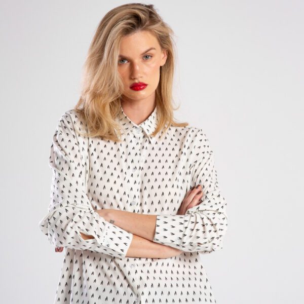 Modelka w koszuli Niigata White od delCane, widok z przodu od połowy sylwetki, ręce splecione z przodu.