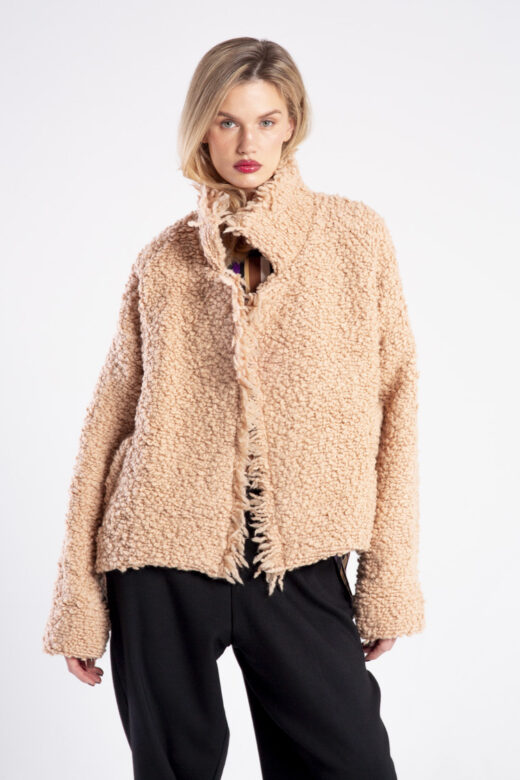 Modelka w kurtce Niigata Boucle od delCane, widok z przodu od kolan w górę, swobodna poza z opuszczonymi rękami.