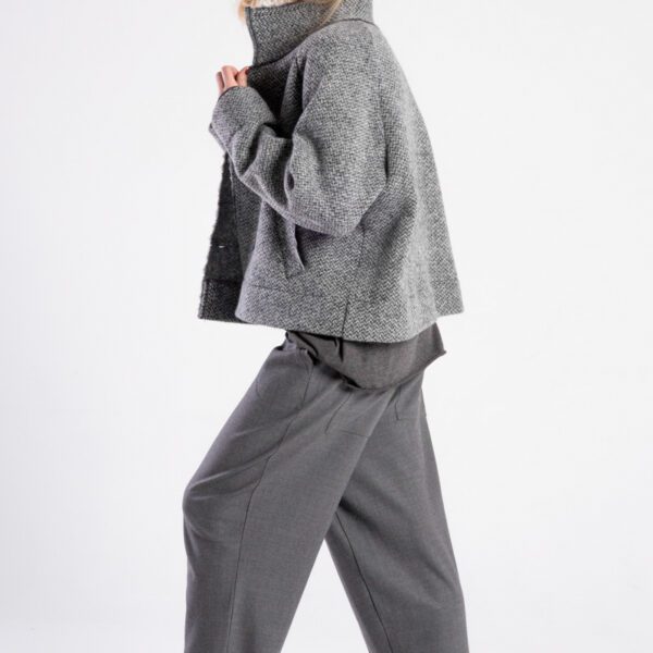 Modelka w kurtce Niigata Grey od delCane, ujęcie z boku w ruchu, widoczny postawiony kołnierz.