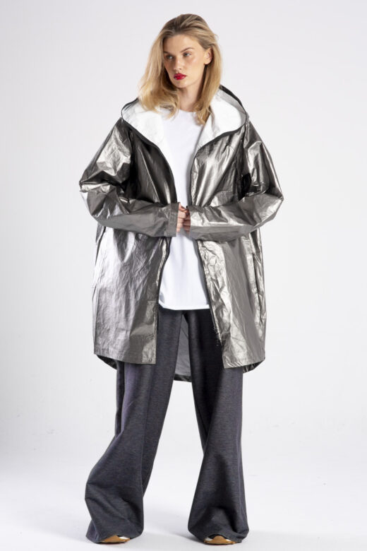 Modelka przodem, cała sylwetka, kurtka rozpięta, trzyma przód kurtki, zdjęcie główne.