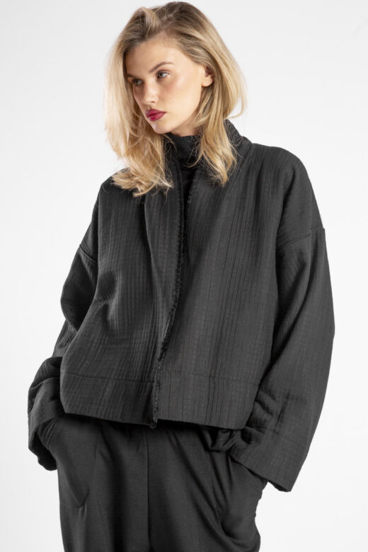 Modelka w kurtce Kimono Niigata Black od delCane, zbliżenie z przodu - widoczna struktura żakardu.