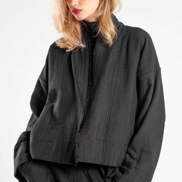 Modelka w kurtce Kimono Niigata Black od delCane, zbliżenie z przodu - widoczna struktura żakardu.