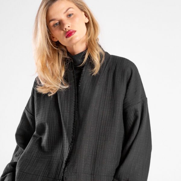 Modelka w kurtce Kimono Niigata Black od delCane, zbliżenie z przodu - widoczna struktura żakardu.