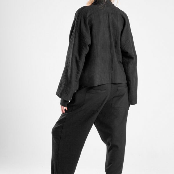 Modelka w kurtce Kimono Niigata Black od delCane, ujęcie tyłobokiem - widoczny tył kurtki.