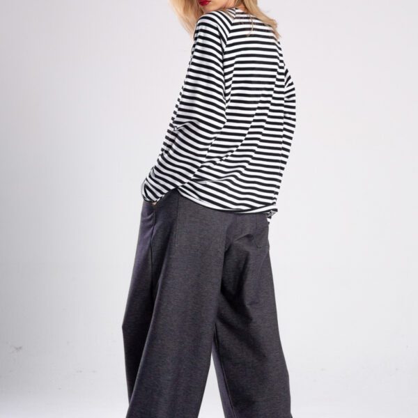 Modelka w longsleeve’ie Niigata Stripes od delCane, widok z tyłu z lekkim obrotem — widać tył i część boku.