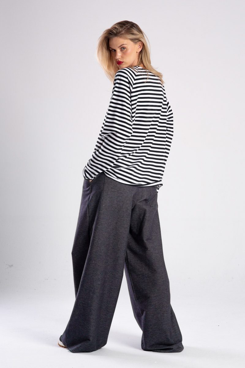 Modelka w longsleeve’ie Niigata Stripes od delCane, widok z tyłu z lekkim obrotem — widać tył i część boku.