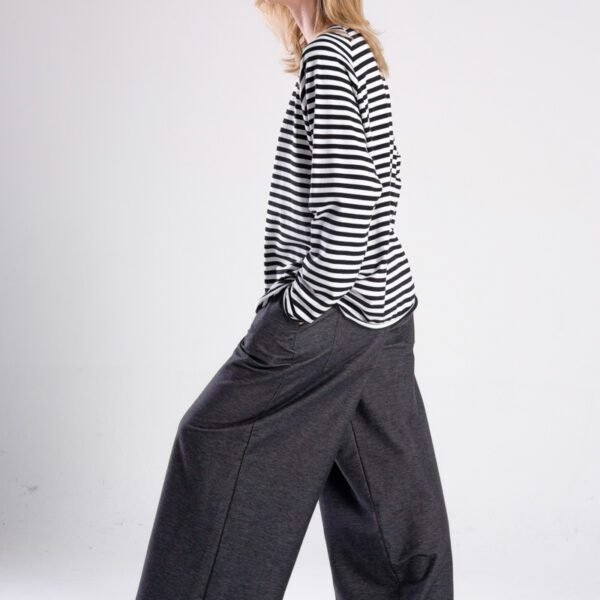 Modelka w longsleeve’ie Niigata Stripes od delCane, widok z boku w ruchu - ręka w kieszeni.