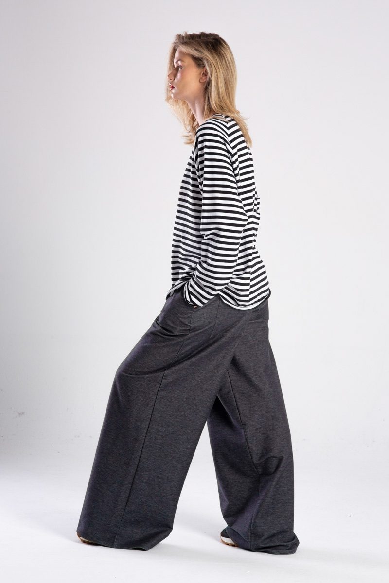 Modelka w longsleeve’ie Niigata Stripes od delCane, widok z boku w ruchu - ręka w kieszeni.