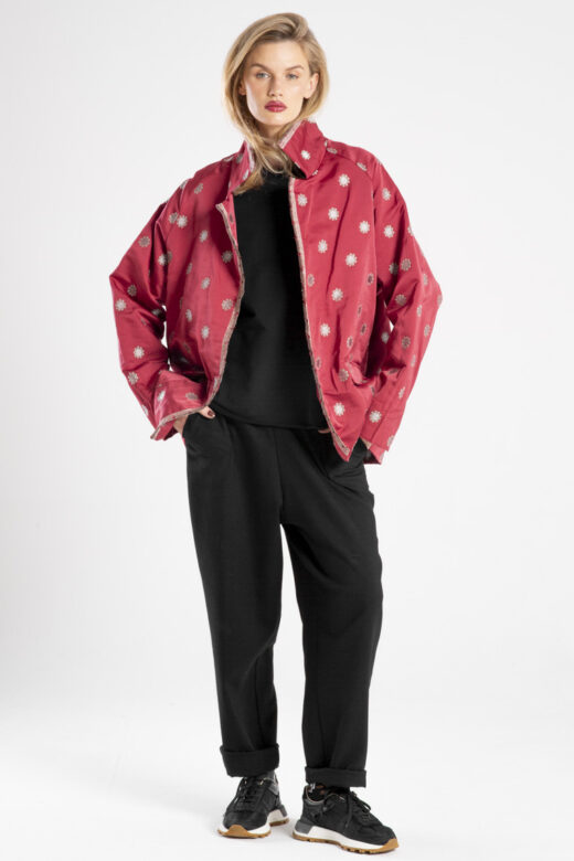 Modelka w marynarce Niigata Red od delCane, ujęcie z przodu, cała sylwetka, luźna poza, ręce w kieszeniach spodni.