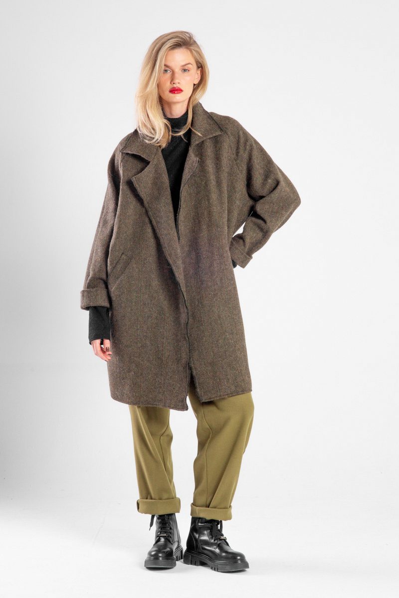 Modelka w płaszczu Niigata Khaki od delCane, widok z przodu, płaszcz rozpięty, luźna poza, widoczna cała sylwetka.