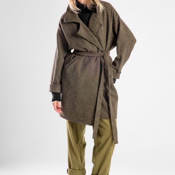 Modelka w płaszczu Niigata Khaki od delCane, widok z przodu, płaszcz przewiązany paskiem, widoczna cała sylwetka.