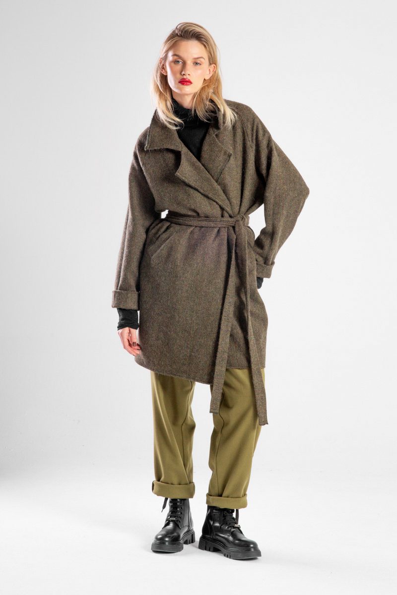 Modelka w płaszczu Niigata Khaki od delCane, widok z przodu, płaszcz przewiązany paskiem, widoczna cała sylwetka.