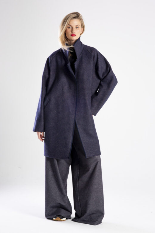 Modelka w płaszczu Niigata Stripes od delCane, widok z przodu, płaszcz rozpięty w swobodnej pozie.