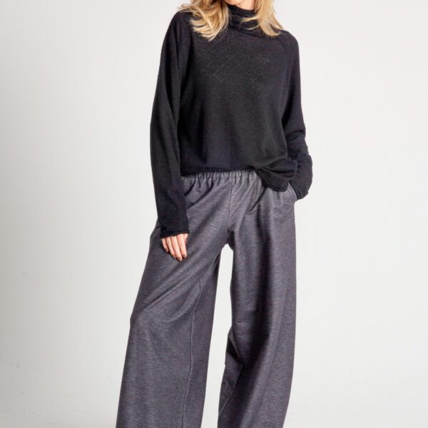 Modelka w spodniach Niigata Jeans od delCane, cała sylwetka przodem - jedna noga lekko ugięta, spojrzenie w bok.