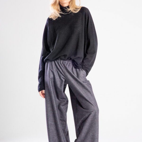 Modelka w spodniach Niigata Jeans od delCane, cała sylwetka przodem — ręka w kieszeni, spojrzenie do przodu.