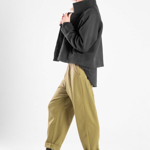 Modelka w spodniach Nigata Wool od delCane, ujęcie z boku w ruchu - pełna sylwetka.