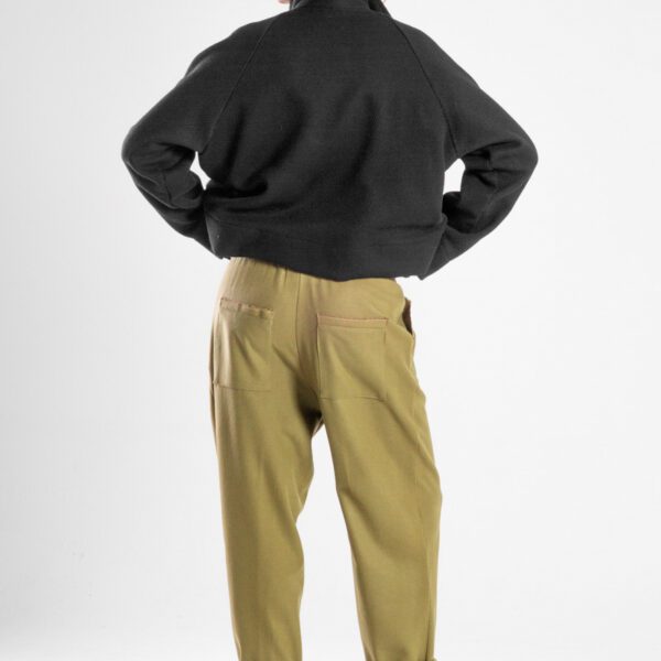 Modelka w spodniach Nigata Wool od delCane, widok z tyłu - pełna sylwetka.