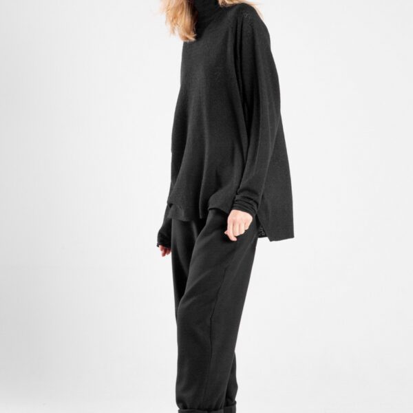 Modelka w czarnym golfie Niigata Cashmere od delCane, ujęcie lekko bokiem z twarzą skierowaną do przodu.