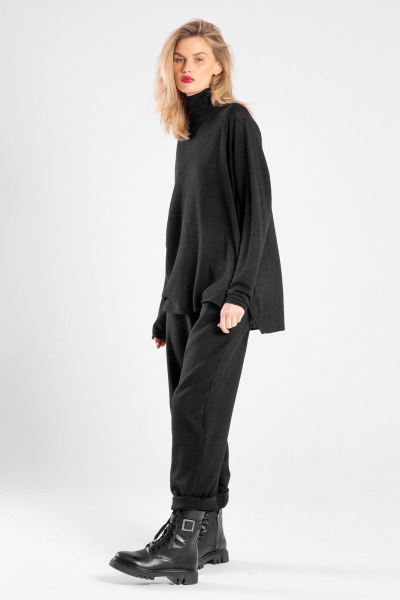 Modelka w czarnym golfie Niigata Cashmere od delCane, ujęcie lekko bokiem z twarzą skierowaną do przodu.
