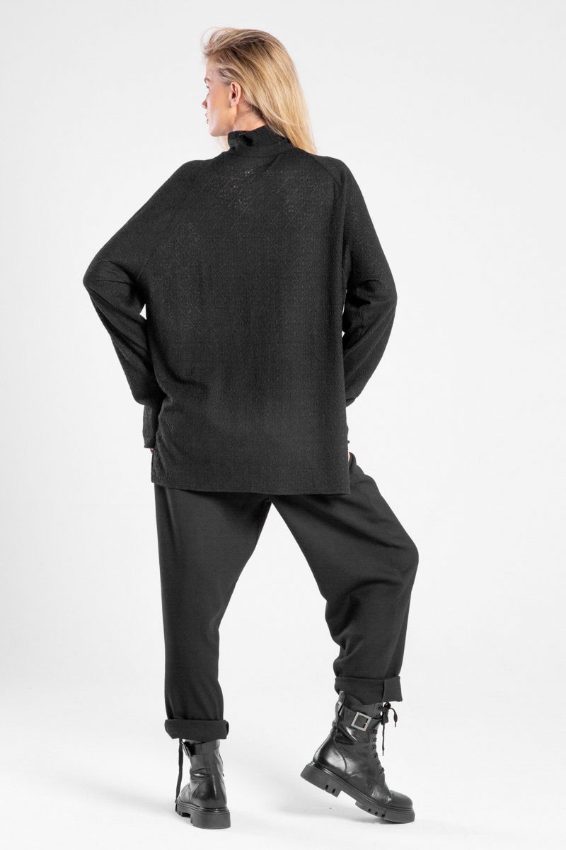 Modelka w czarnym golfie Niigata Cashmere od delCane, widok z tyłu z delikatnie widocznym profilem twarzy.
