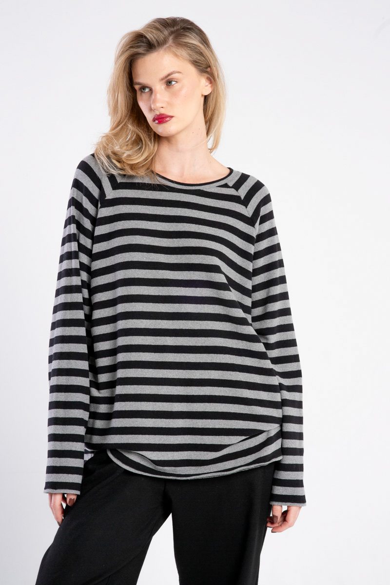 Modelka w swetrze Niigata Stripes od delCane, ujęcie z przodu w zbliżeniu, widoczne detale tkaniny i pasiasty wzór, ręce opuszczone.