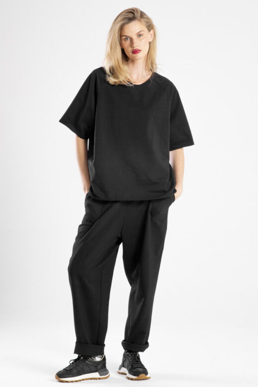 modelka w t-shircie Niigata Black, pełna sylwetka przodem, ręce w kieszeniach spodni, patrzy w obiektyw, widoczny cały t-shirt