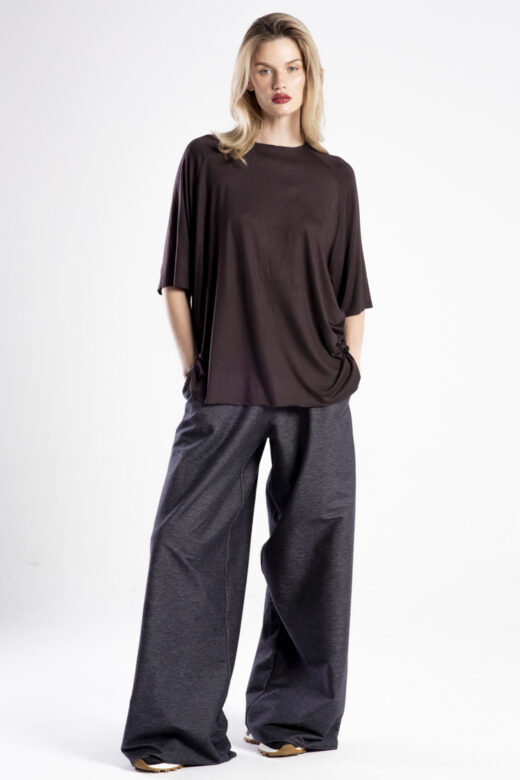 Modelka przodem w brązowym t-shircie Niigata Brown, cała sylwetka, ręce w kieszeniach.