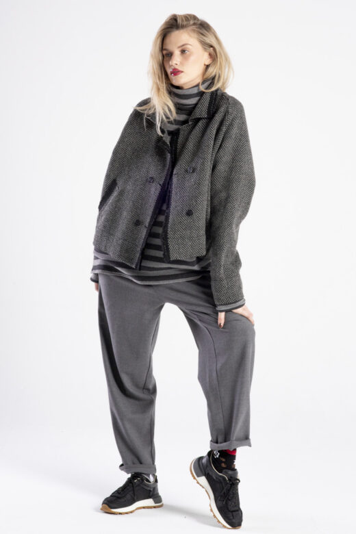 modelka w kurtce Niigata Grey and Black, pełna sylwetka przodem, kurtka rozpięta, jedna noga ugięta, ręka oparta na udzie