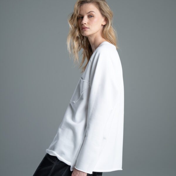 Modelka bokiem w bluzie Noda White, ujęcie od kolan w górę