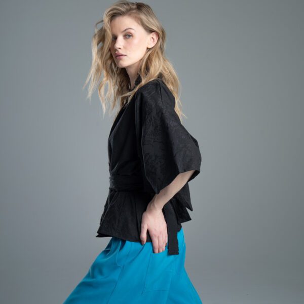 Modelka bokiem prezentuje kimono Noda Black, ujęcie od kolana w górę, ręka oparta na biodrze, wyraźnie widać bok kimona związanego paskiem.