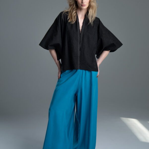 Modelka przodem prezentuje kimono Noda Black w pełnej sylwetce, ręce ma oparte na biodrach, kimono jest rozpięte.