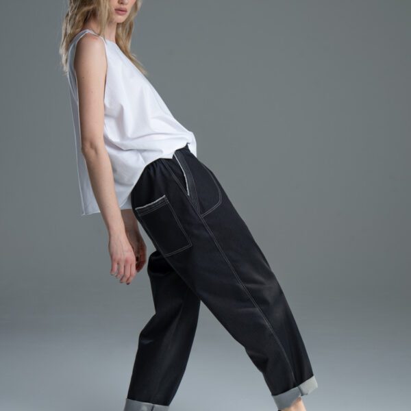 Modelka w spodniach Noda Black, ujęcie z boku, cała sylwetka