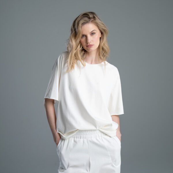 Modelka przodem w T-shircie Noda Ecru, od kolan w górę, widoczny przód T-shirtu