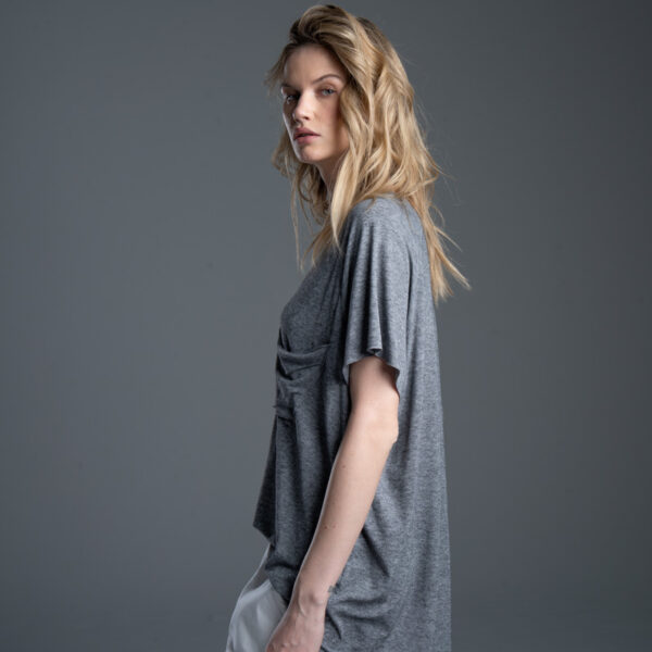 Modelka bokiem w T-shircie Noda Gray, ujęcie od uda w górę