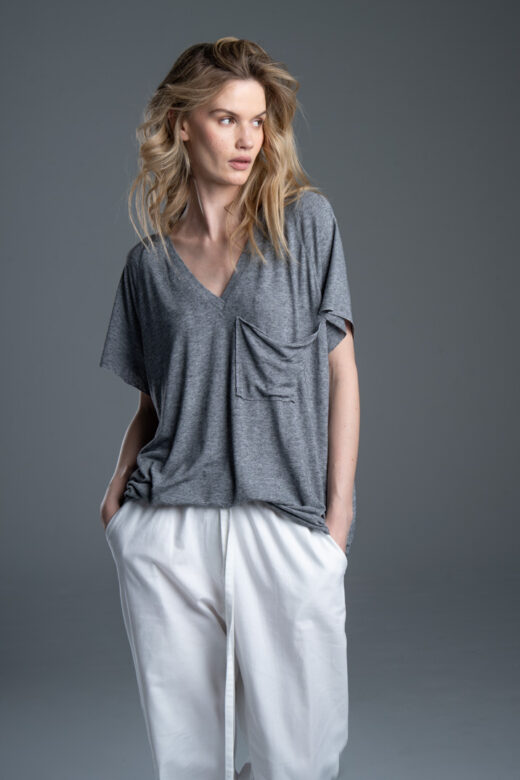 Modelka przodem w t-shircie Noda Gray, ujęcie od kolan w górę