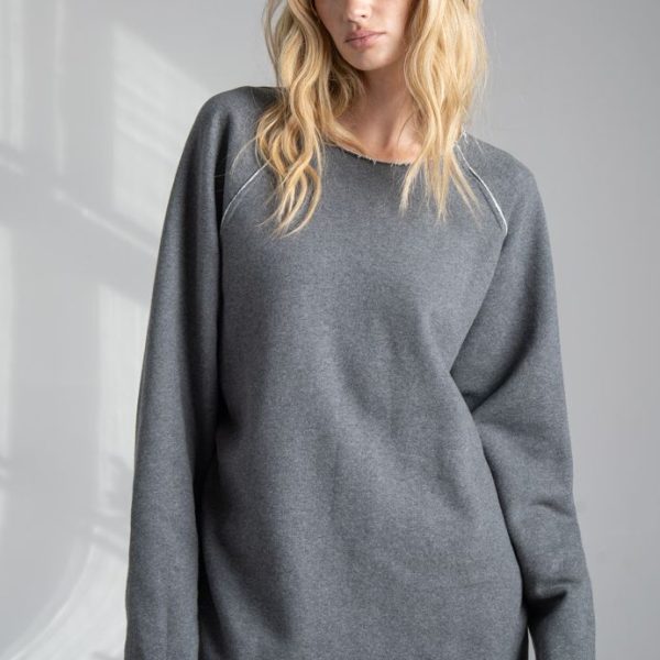 Szara bluza Mino Gray delCane z bawełny. Zbliżenie na przód bluzy, modelka ustawiona przodem, widoczna od ud w górę, z rękami opuszczonymi wzdłuż ciała.