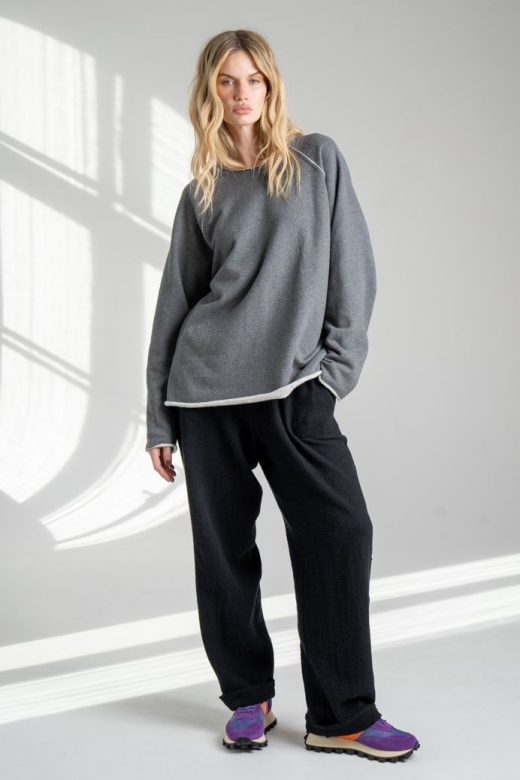 Szara bluza Mino Gray delCane z bawełny. Modelka w pełnej sylwetce, ustawiona przodem, z jedną nogą lekko ugiętą i ręką w kieszeni spodni.