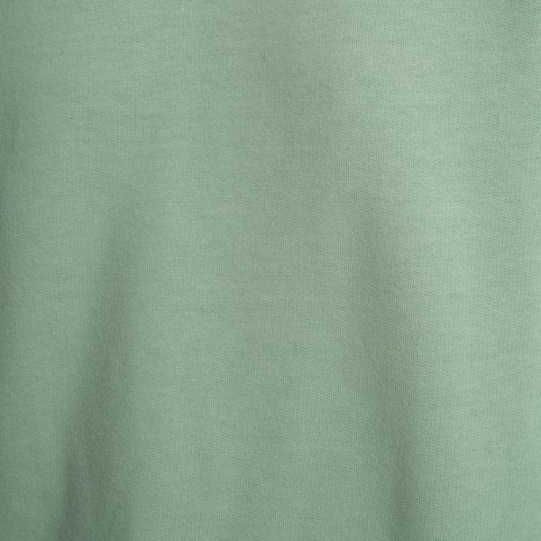 Zbliżenie na bawełnianą dzianinę bluzy Mino Green delCane. Wyraźnie widoczny miętowy odcień zieleni oraz faktura materiału.