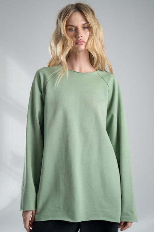 Bluza Mino Green delCane w miętowym odcieniu zieleni. Modelka przodem, widoczna od uda w górę, z rękami opuszczonymi wzdłuż ciała. Wyraźnie widoczny cały przód bluzy.