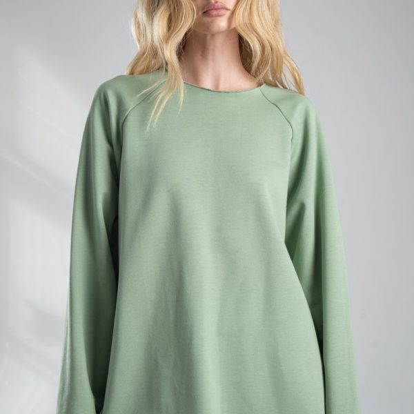 Bluza Mino Green delCane w miętowym odcieniu zieleni. Modelka przodem, widoczna od uda w górę, z rękami opuszczonymi wzdłuż ciała. Wyraźnie widoczny cały przód bluzy.