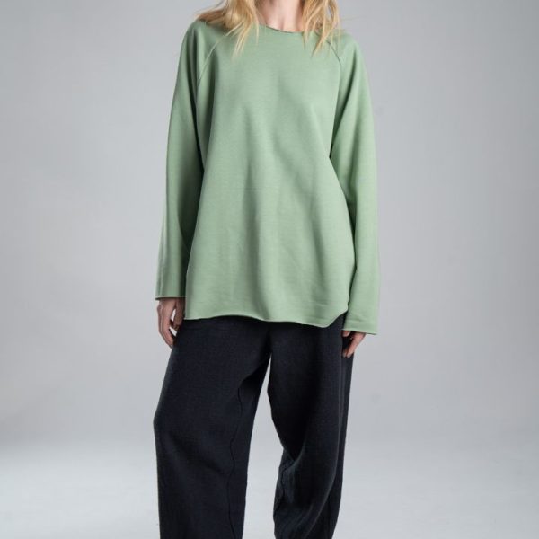 Bluza Mino Green delCane w miętowym odcieniu zieleni. Modelka przodem, w pełnej sylwetce, z rękami opuszczonymi wzdłuż ciała. Wyraźnie widoczny cały przód bluzy.