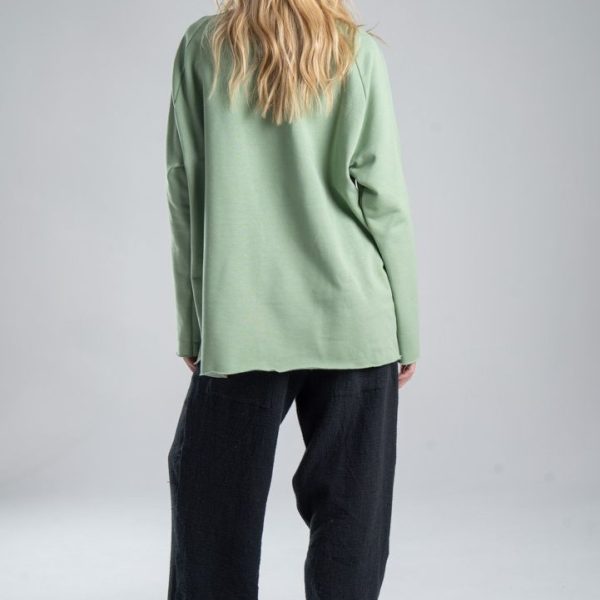 Bluza Mino Green delCane w miętowym odcieniu zieleni. Modelka tyłem, w pełnej sylwetce. Wyraźnie widoczny cały tył bluzy.