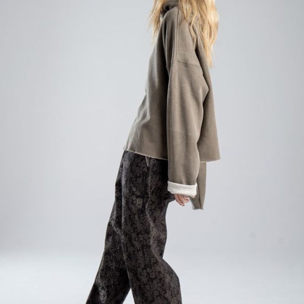 Bluza Mino Stone delCane w szarobeżowym kolorze. Modelka w pełnej sylwetce, widok z boku prezentujący krótki, luźny fason oversize.