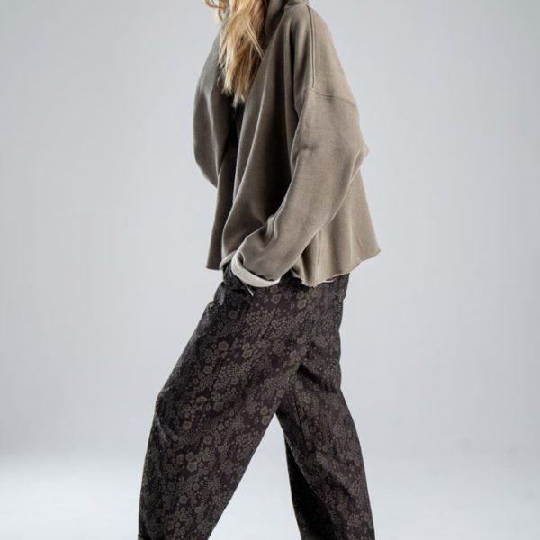 Bluza Mino Stone delCane w szarobeżowym kolorze. Modelka w pełnej sylwetce, ustawiona bokiem, z kapturem na głowie i ręką w kieszeni spodni.