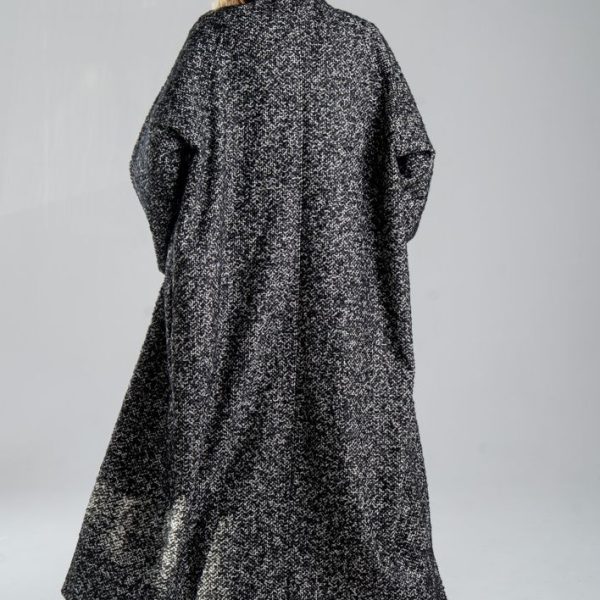 Cardigan Mino Wool delCane w czarno-białym melanżu. Modelka tyłem, w pełnej sylwetce. Wyraźnie widoczny cały tył cardiganu.