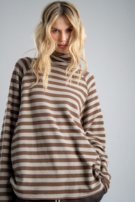Sweter z golfem Mino Stripes delCane w beżowo-brązowe paski. Mocne zbliżenie od przodu, wyraźnie widoczny golf, wzór w paski i luźny fason swetra.