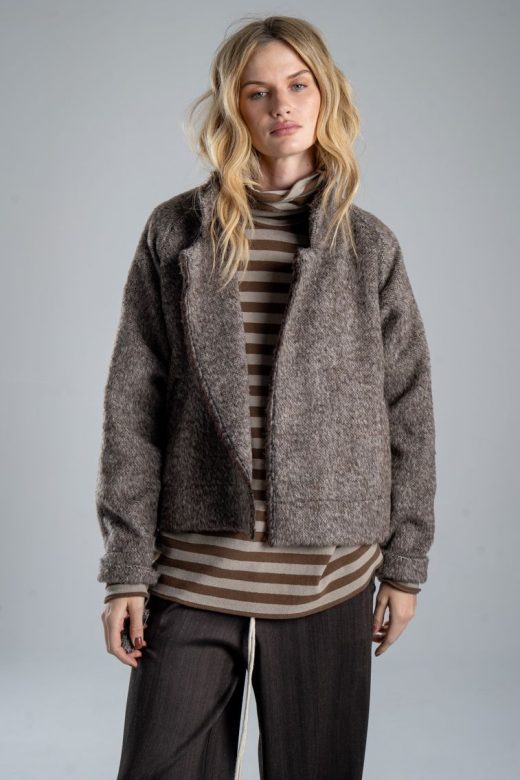 Kurtka Mino Wool delCane w brązowym melanżu. Mocne zbliżenie od przodu, modelka widoczna od ud w górę, prezentuje rozpiętą kurtkę z włoskiej wełny.